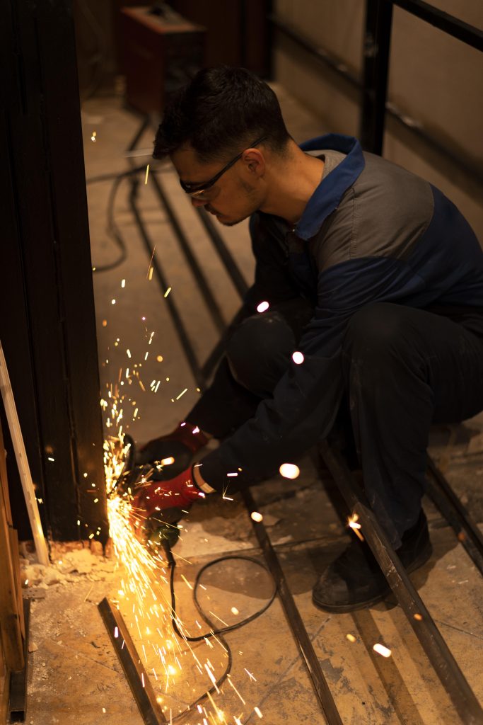 man using angle grinder with sparks